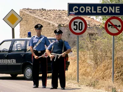 Italian carabinieri (military police) stand guard outside the small Sicilian town of Corleone in this 1992 file photo. Bernardo Provenzano, the undisputed chief of the Sicilian Mafia who had been on the run for more than four decades, was arrested while hiding in a farmhouse near Corleone in Sicily on April 11, 2006 officials said. Provenzano, known as the "Phantom of Corleone" after his native hill town, made famous by the Godfather films, has been running the Mafia since former "boss of bosses" Toto Riina was arrested in 1993. REUTERS/Tony Gentile