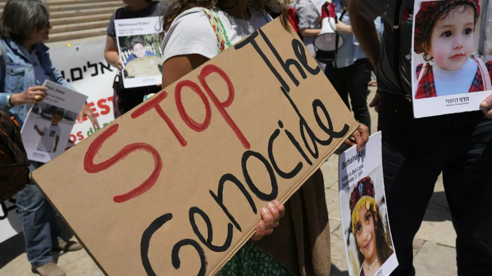 Protestors hold pictures of Palestinian children killed in Gaza during a demonstration organized by Israeli citizens demanding action from the European Union against the government of Israel to stop the war, outside the Portuguese parliament in Lisbon, Tuesday, May 27, 2025. (AP Photo/Armando Franca)