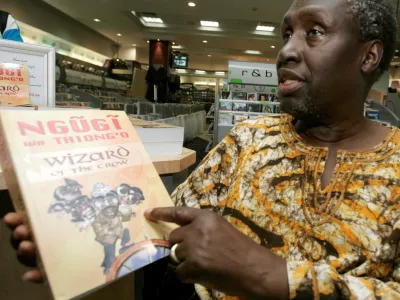 FILE PHOTO: Kenyan author Ngugi Wa Thiong'o shows his newly launched book "Wizard of the Crow" during an interview with Reuters at a bookshop in downtown Nairobi January 16, 2007. The book, which took Wa Thiong'o more than six years to write, was released on Monday, about 20 years after his novel "Matigari". REUTERS/Antony Njuguna/File Photo