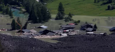 A few remaining houses are seen after a massive rock and ice slide covered most of the village of Blatten, Switzerland May 29, 2025. REUTERS/Stefan Wermuth