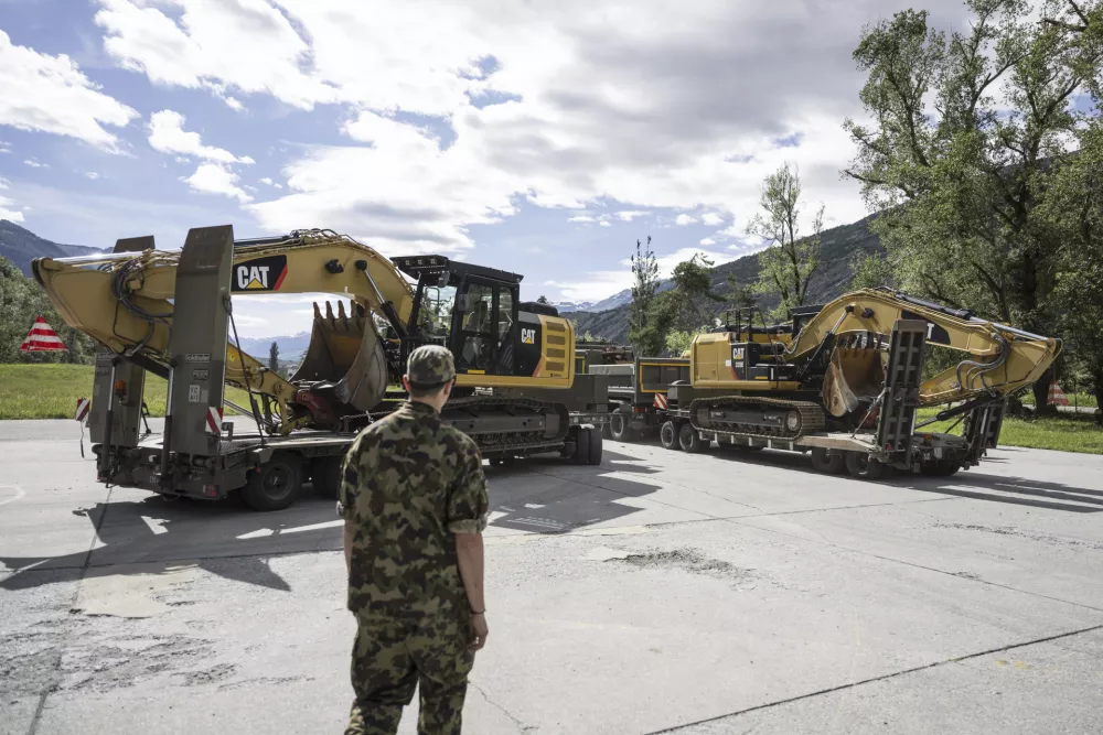 Soldiers of the Military Disaster Relief (Kata Hi Ber Bat) of the Swiss Army load heavy machinery onto trailers to aid the site of the catastrophic mud slide that caused major distruction to the village of Blatten, on the Army base in Turtmann, Switzerland, Thursday, May 29, 2025. (Alessandro della Valle/Keystone via AP)
