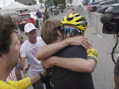 Britain's Simon Yates hugs a team' staffer after completing the stage 20 and take the lead of the Giro d'Italia cycling race, from Verres to Sestriere (Via Lattea), Italy, Saturday, May 31, 2025. (Gian Mattia D'Alberto /LaPresse via AP)