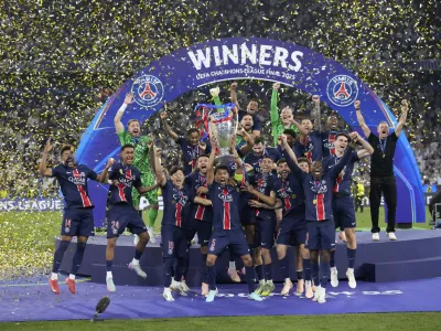 PSG players celebrate with the trophy after winning the Champions League final soccer match between Paris Saint-Germain and Inter Milan at the Allianz Arena in Munich, Germany, Saturday, May 31, 2025. (AP Photo/Matthias Schrader)