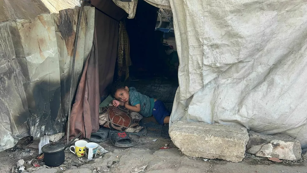A Palestinian child lies inside the tent he took shelter in with his family after being displaced, in Gaza City May 25, 2025. REUTERS/Stringer  TPX IMAGES OF THE DAY
