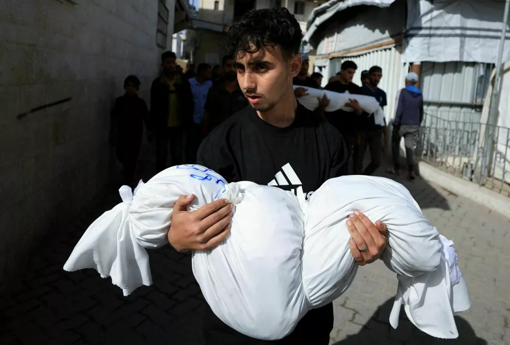 A mourner holds a body during the funeral of Palestinians killed in Israeli strikes, at Al-Ahli Arab Baptist hospital, in Gaza City, May 26, 2025. REUTERS/Dawoud Abu Alkas  TPX IMAGES OF THE DAY