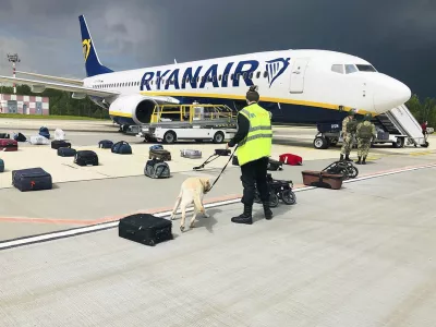 FILE - In this May 23, 2021, file photo provided by ONLINER.BY, security use a dog to check the luggage of passengers on the Ryanair jet that carried opposition figure Raman Pratasevich, traveling from Athens to Vilnius, Lithuania. The plane was diverted to Minsk, Belarus, after Belarusian flight controllers told the crew that there was a bomb threat against the plane. Pratasevich, who ran a channel on a messaging app used to organize demonstrations against authoritarian President Alexander Lukashenko, left his homeland in 2019 to try to escape the reach of the Belarusian KGB. Pratasevich was arrested upon landing in Minsk and faces 15 years in prison on charges of inciting disturbances. ď&raquo;żď&raquo;ż(ONLINER.BY via AP)