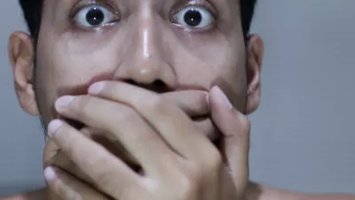 frightened asian man covering his mouth with both hands, expressing surprise, fear, or disbelief on grey blurry background / Foto: Muhammad Faris