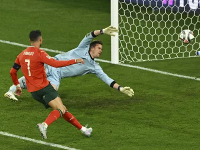 Portugal's Cristiano Ronaldo, left, scores his side's second goal during the Nations League semifinal soccer match between Portugal and Germany in Munich, Germany, Wednesday, June 4, 2025. (Peter Kneffel/dpa via AP)