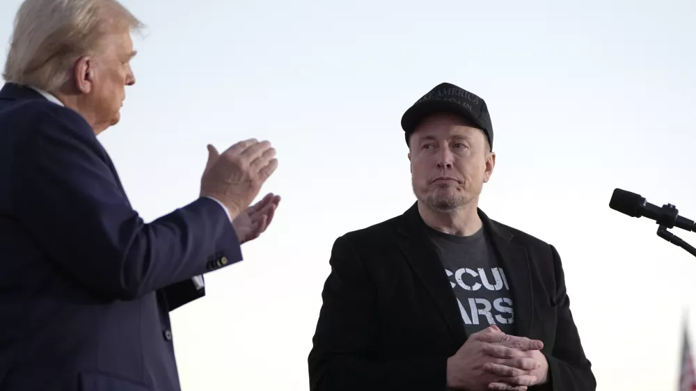 FILE - Republican presidential nominee former President Donald Trump, left, claps as Tesla and SpaceX CEO Elon Musk prepares to depart after a campaign event at the Butler Farm Show on Oct. 5, 2024, in Butler, Pa. (AP Photo/Alex Brandon, File)