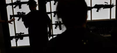 FILE PHOTO: A man looks at an AR-15 rife at an exhibition booth during the National Rifle Association (NRA) annual convention in Dallas, Texas, U.S., May 18, 2024. REUTERS/Carlos Barria/File Photo