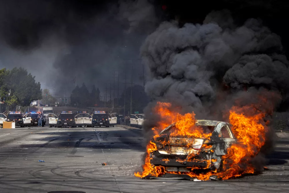A car burns on Atlantic Boulevard during a standoff by protesters and law enforcement, following multiple detentions by Immigration and Customs Enforcement (ICE), in the Los Angeles County city of Compton, California, U.S., June 7, 2025.  REUTERS/Barbara Davidson   TPX IMAGES OF THE DAY REFILE - CORRECTING LOCATION FROM "PARAMOUNT" TO "COMPTON".