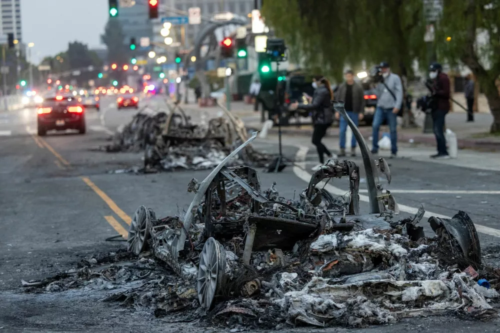 Members of the media report from Los Angeles Street where Waymo cars were burned yesterday, after the California National Guard was deployed by U.S. President Donald Trump as a response to protests against federal immigration sweeps, in downtown Los Angeles, California, U.S., June 9, 2025.  REUTERS/Jill Connelly