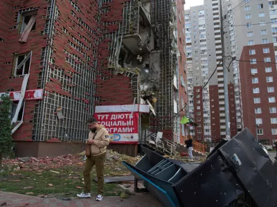 Residents react near their damaged multi-storey building damaged in Russia's massive missile and drone attack in Kyiv, Ukraine, Tuesday, June 10, 2025. (AP Photo/Efrem Lukatsky)