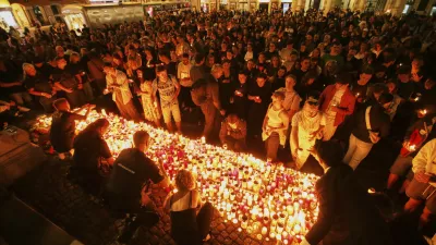People light candles on the main square in the city center after a deadly shooting at a school in Graz, Austria, Tuesday, June 10, 2025. (AP Photo/Heinz-Peter Bader)