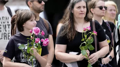 People pay a moment of silence on the main square after a former student opened fire the day before at a school fatally wounding several people and injuring many others before taking his own life, Graz, Austria, Wednesday, June 11, 2025. (AP Photo/Darko Bandic)