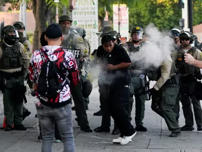 A person reacts to non-lethal munitions shot by a member of the law enforcement, as people protest against federal immigration sweeps, in downtown Los Angeles, California, U.S. June 11, 2025. REUTERS/David Ryder