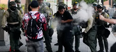 A person reacts to non-lethal munitions shot by a member of the law enforcement, as people protest against federal immigration sweeps, in downtown Los Angeles, California, U.S. June 11, 2025. REUTERS/David Ryder