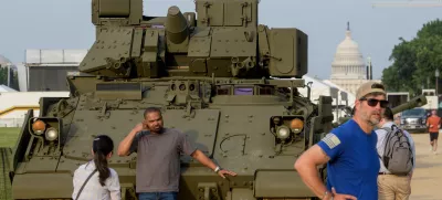 People pass by and take photos with a tank, parked on the National Mall, during preparations for an upcoming military parade commemorating the Army's 250th anniversary and coinciding with President Donald Trump's 79th birthday, Thursday, June 12, 2025, in Washington. (AP Photo/Rod Lamkey, Jr.)