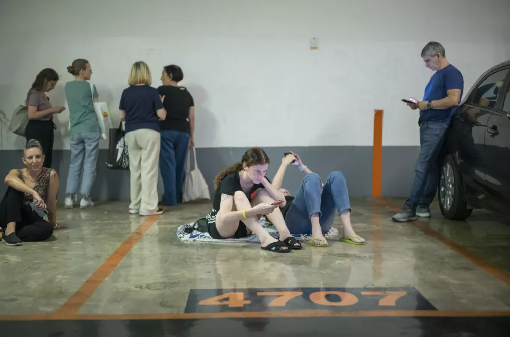 14 June 2025, Israel, Tel Aviv: People seek shelter as sirens sound during a missile strike in Ramat Gan, near Tel Aviv, where several cars and buildings were destroyed. The attack was part of a large-scale Iranian missile barrage on June 13, launched in retaliation for Israeli strikes on senior military officials and strategic sites in Iran. Photo: Ilia Yefimovich/dpa