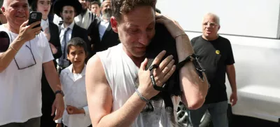 Eli Bachar, 40, reacts as he holds his dog Tess, who was rescued from a building that was hit at an impact site following missile attack from Iran on Israel, in Ramat Gan, Israel, June 14, 2025. REUTERS/Ronen Zvulun