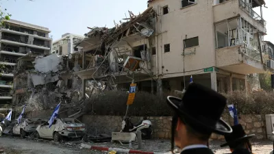 People look at damaged buildings at an impact site following missile attack from Iran on Israel, in Ramat Gan, Israel, June 14, 2025. REUTERS/Ronen Zvulun