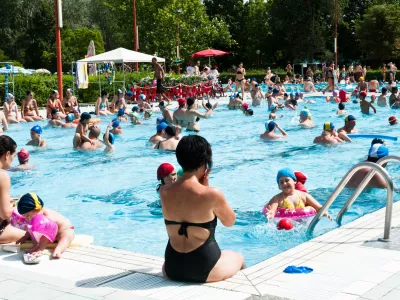 "Bologna, Italy - July 1, 2012: Adulta and families with children refreshing themself and having fun in a crowded swimming pool near Bologna (Italy). It's a sunny day, during a very hot summer."