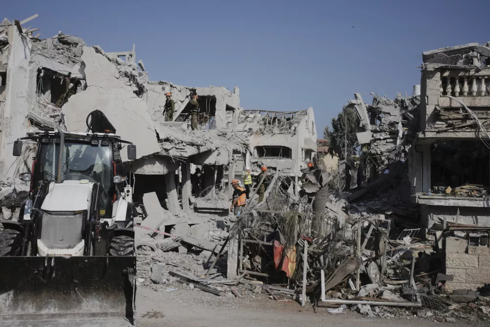Israeli security forces inspect the site of homes destroyed by a missile fired from Iran, in Rishon Lezion, Israel, on Saturday, June 14, 2025. (AP Photo/Ohad Zwigenberg)