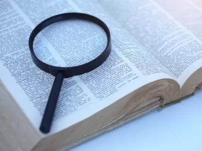 Megnifying glass on page of dictionary. Concept, Word searching. Education