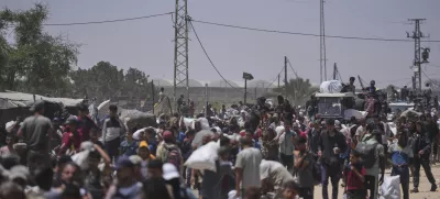 Palestinians carry bags containing food and humanitarian aid packages delivered by the Gaza Humanitarian Foundation, a U.S.-backed organization, in Rafah, southern Gaza Strip, Monday, June 16, 2025. (AP Photo/Abdel Kareem Hana)