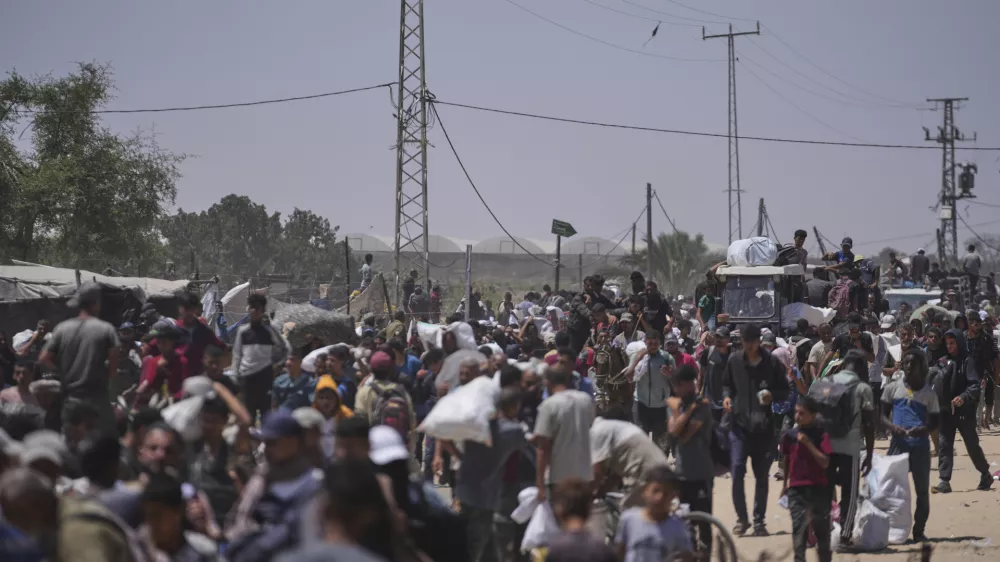 Palestinians carry bags containing food and humanitarian aid packages delivered by the Gaza Humanitarian Foundation, a U.S.-backed organization, in Rafah, southern Gaza Strip, Monday, June 16, 2025. (AP Photo/Abdel Kareem Hana)