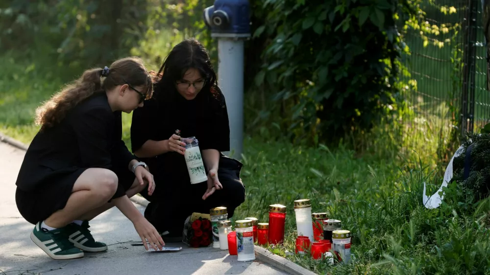 People light candles outside the site of a deadly shooting at a secondary school, in Graz, Austria, June 11, 2025. REUTERS/Borut Zivulovic / Foto: Borut Zivulovic