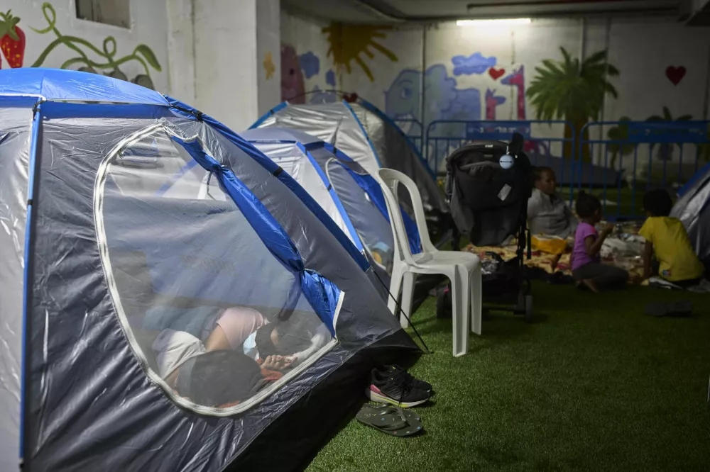 People spend the night in a public shelter as a precaution against possible Iranian missile attacks, in Tel Aviv, Israel, Saturday, June 21, 2025. (AP Photo/Ohad Zwigenberg)