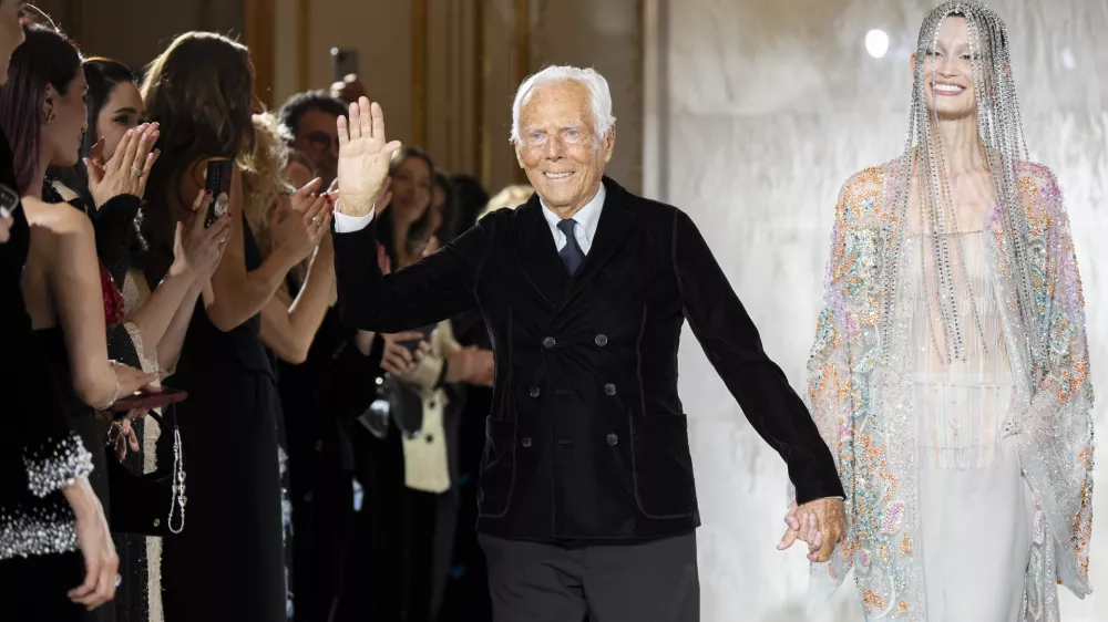 FILE - Giorgio Armani gestures at the end of the Giorgio Armani Prive Haute Couture Spring Summer 2025 collection in Paris, on Jan. 28, 2025. (AP Photo/Lewis Joly, File).