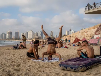 21 June 2025, Israel, Tel-aviv: As tensions between Israel and Iran mount, people seek a brief escape at the beach-soaking up the sun and sea in a quiet moment of normalcy amid growing unease. Photo: Ilia Yefimovich/dpa