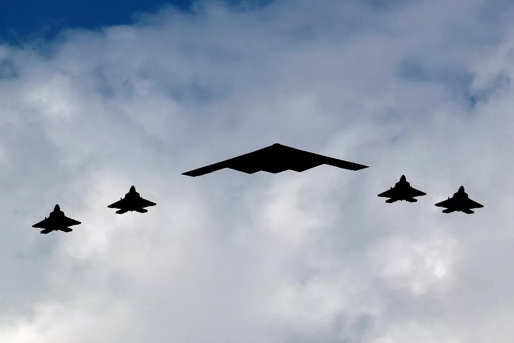 A U.S. Air Force B-2 Spirit Stealth Bomber (C) is flanked by four F-22 Raptor fighter planes during a flyover of military aircraft down the Hudson River and New York Harbor past York City, and New Jersey, U.S. July 4, 2020. REUTERS/Mike Segar REFILE - CORRECTING AIRCRAFT FROM "U.S. MARINE CORPS F-35 FIGHTERS" TO "F-22 RAPTOR FIGHTER PLANES".