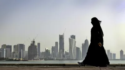 FILE- In this May 14, 2010 file photo, a Qatari woman walks in front of the city skyline in Doha, Qatar. An investigation into why a British man fell to his death on a Qatar World Cup site has raised concerns about stadium roof safety. Acting as a mediator, Kuwait has presented Qatar a long-awaited list of demands from Saudi Arabia, Bahrain, the United Arab Emirates and Egypt, four Arab nations that cut ties with Qatar in early June, 2017. (AP Photo/Kamran Jebreili, File)