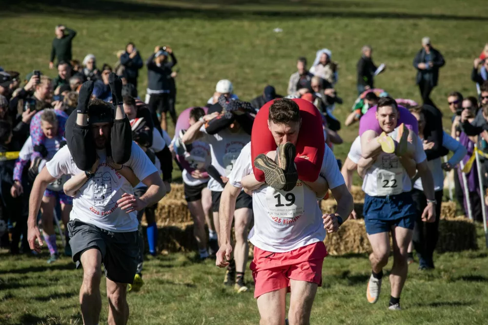 DORKING, UNITED KINGDOM - 2025/03/16: Winning couple (centre) Stuart Johnson and Hattie Cronin lead the Wife Carrying Race. Very first run of the UK Wife Carrying Race was in 2008. This sport originated from Scandinavia. The winning couple qualifies to go to the annual World Wife Carrying Championships in Finland. (Photo by Krisztian Elek/SOPA Images/LightRocket via Getty Images) / Foto: Sopa Images