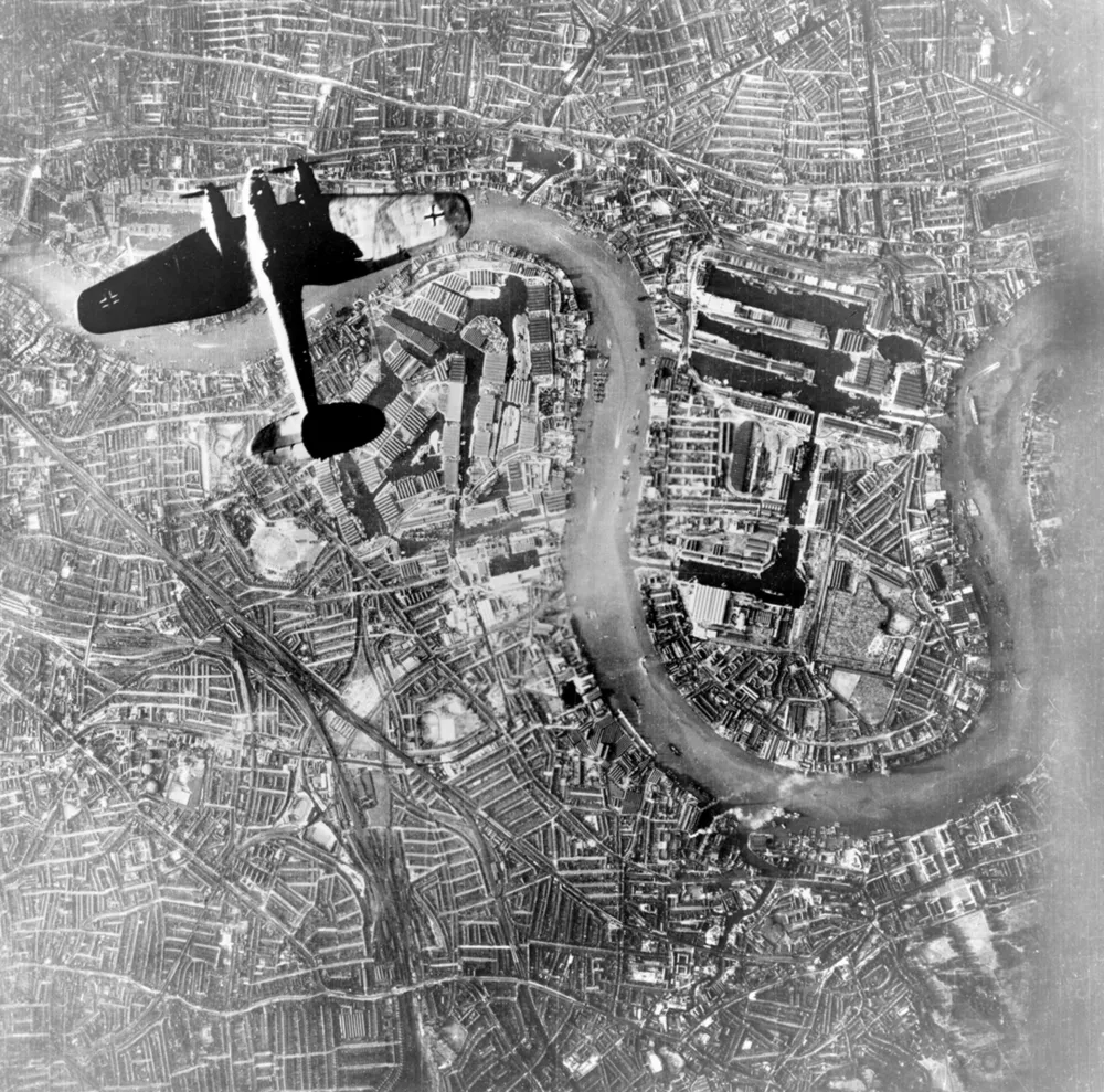 Kopija negativa dela zračne fotografije, posnete z nem&scaron;kega letala ob 18.48 po nem&scaron;kem času, na kateri vidimo nem&scaron;ki bombnik Luftwaffe Heinkel He 111, ki leti nad Wappingom in otokom Isle of Dogs v vzhodnem delu Londona na začetku večernih napadov. / Foto: Wikipedija