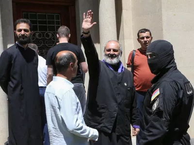 Archbishop of the Armenian Apostolic Church Bagrat Galstanyan, who is charged with attempting to overthrow the government and destabilizing the state, waves to supporters as Armenia's National Security officers arrive to arrest him in Yerevan, Armenia, June 25, 2025. Melik Baghdasaryan/Photolure via REUTERS ATTENTION EDITORS - THIS IMAGE HAS BEEN SUPPLIED BY A THIRD PARTY.