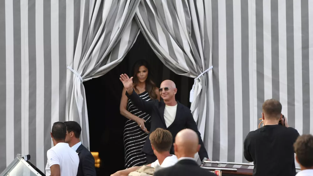 Amazon multi-billionaire founder Jeff Bezos, right, and Lauren Sanchez leave a hotel in Venice, Italy, on Wednesday, June 25, 2025, ahead of festivities in the lagoon city reportedly linked to their wedding. (AP Photo/Luigi Costantini)