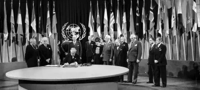 FILE - President Harry S. Truman and the entire American delegation watch as Sen. Tom Connally signs the United Nations Charter in San Francisco, June 26, 1945. Standing, from left, after Truman are Secretary of State Edward Stettinius Jr.; Harold Edward Stassen; unidentified; Dean Virginia Gildersleeve; Rep. Charles A. Eaton; Rep. Sol Bloom, and Sen. Arthur Vandenberg. (AP Photo, File)