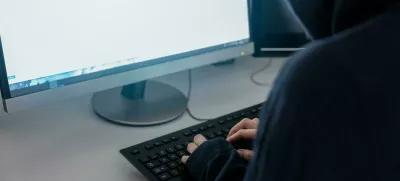 M8JWG4 anonymous hacker in the hoodie, breaks the access to steal information and infect computers and systems. the concept of hacking and cyber war