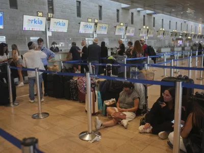 Travelers line up to check in for a flight following the announcement of a ceasefire between Israel and Iran, at Ben Gurion International Airport, near Tel Aviv, Israel, Wednesday, June 25, 2025. (AP Photo/Ohad Zwigenberg)
