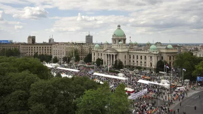 Government supporters hold a banner that reads "Blockaders - Remember - Serbia is not a genocidal state" outside the Parliament building ahead of a major anti-government rally pressing for an early election after nearly eight months of almost daily anti-corruption demonstrations that have shaken the populist government of President Aleksandar Vucic, in Belgrade, Serbia, Saturday, June 28, 2025. (AP Photo/Darko Vojinovic)