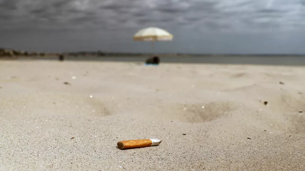 A discarded cigarette butt lies on the sand of La Baule beach on the Atlantic coast, as a nationwide ban on smoking is due to come into effect on July 1, at beaches, parks and outside schools to protect children, France, June 25, 2025. REUTERS/Stephane Mahe