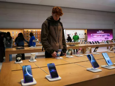FILE PHOTO: A person looks at iPhones in the Apple Fifth Avenue store in New York City, U.S., May 23, 2025. REUTERS/Adam Gray/File Photo