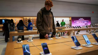 FILE PHOTO: A person looks at iPhones in the Apple Fifth Avenue store in New York City, U.S., May 23, 2025. REUTERS/Adam Gray/File Photo