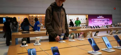 FILE PHOTO: A person looks at iPhones in the Apple Fifth Avenue store in New York City, U.S., May 23, 2025. REUTERS/Adam Gray/File Photo