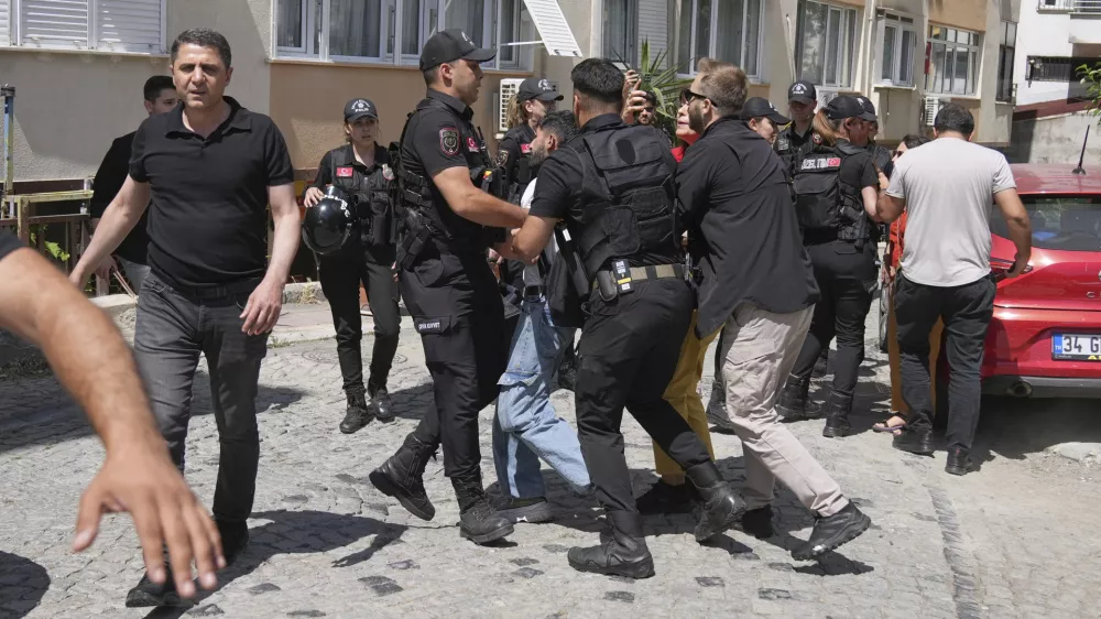 A man is detained by Turkish police officers as he tries to gather with others to celebrate the annual LGBTQ+ Pride March, in Istanbul, Turkey, Sunday, June 29, 2025. (AP Photo/Dilara Acikgoz)