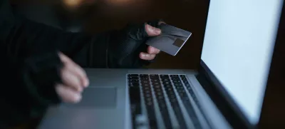 2M52K83 Secure yourself from becoming the next victim of fraud. an unrecognisable hacker using a laptop to hack into a credit account.